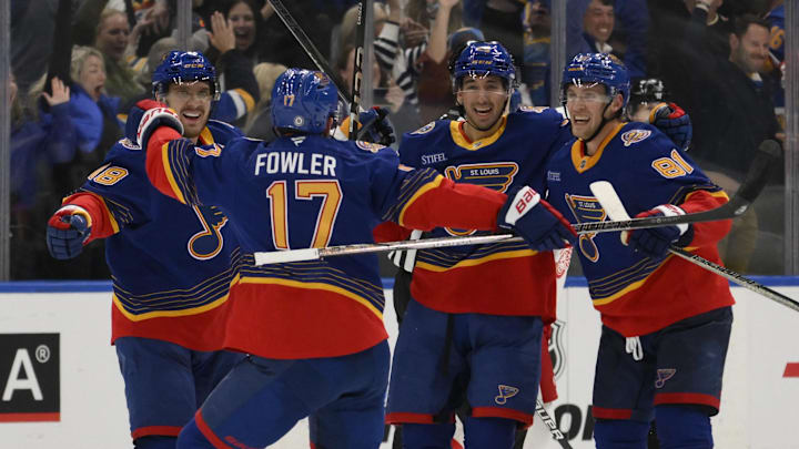 Apr 1, 2025; St. Louis, Missouri, USA; St. Louis Blues center Jordan Kyrou (25) celebrates with defenseman Cam Fowler (17), center Dylan Holloway (81), and center Robert Thomas (18) after scoring a goal against the Detroit Red Wings during the third period at Enterprise Center. Mandatory Credit: Jeff Le-Imagn Images