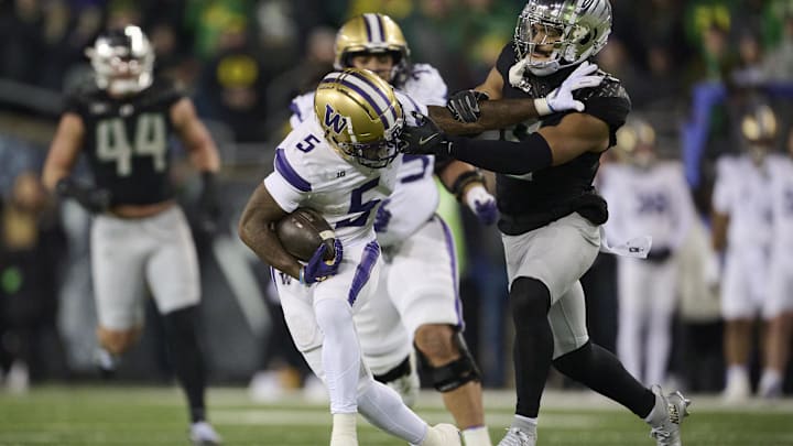Nov 30, 2024; Eugene, Oregon, USA; Washington Huskies wide receiver Giles Jackson (5) catches a pass for a first down during the first half as Oregon Ducks defensive back Kobe Savage (5) is called for face masking on the play at Autzen Stadium. Mandatory Credit: Troy Wayrynen-Imagn Images