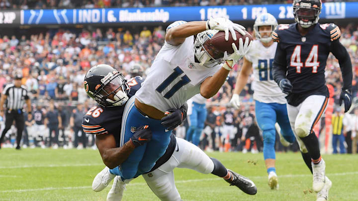 Lions receiver Kalif Raymond tries to reach out from the grasp of former Bears safety Deon Bush at Soldier Field. 