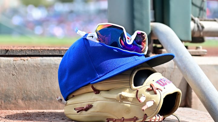 Feb 27, 2024; Mesa, Arizona, USA;  General view of a Chicago Cubs glove, hat and glasses in the first inning against the Cincinnati Reds during a spring training game at Sloan Park. Mandatory Credit: Matt Kartozian-Imagn Images