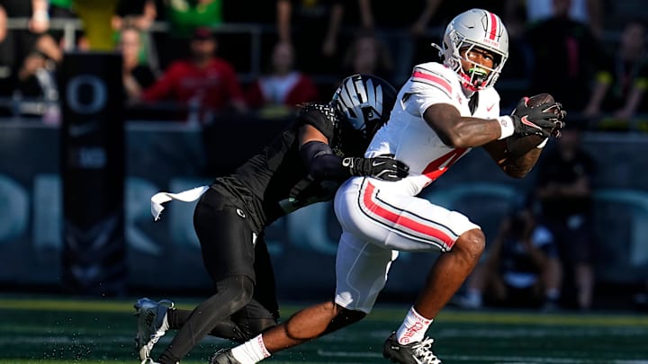 Oct 12, 2024; Eugene, Oregon, USA; Ohio State Buckeyes wide receiver Jeremiah Smith (4) catches a pass and is tackled by Oregon Ducks defensive back Brandon Johnson (3) during the first half of the NCAA football game at Autzen Stadium