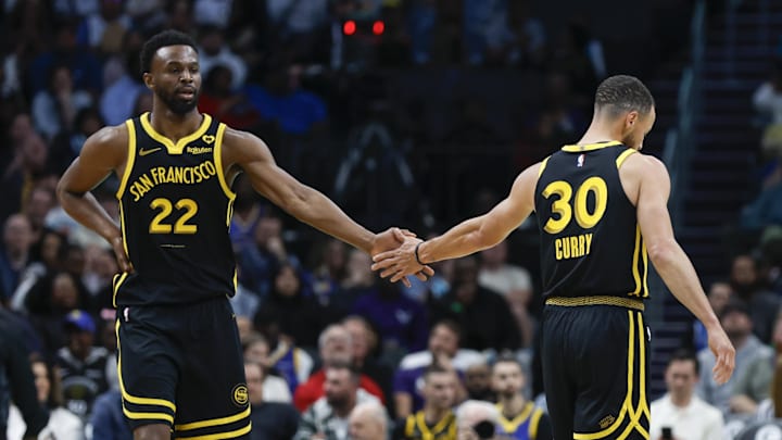 Golden State Warriors forward Andrew Wiggins (22) celebrates with Golden State Warriors guard Stephen Curry (30) after scoring against the Charlotte Hornets during the first quarter at Spectrum Center.