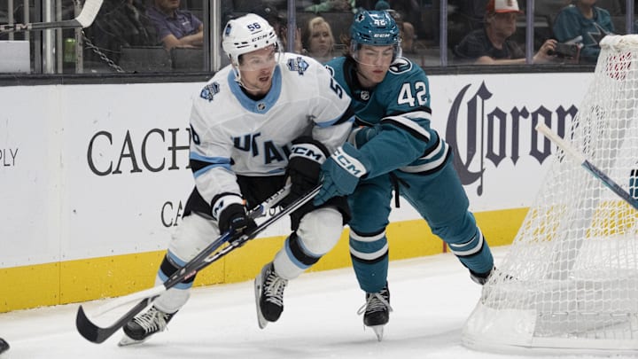 Oct 1, 2024; San Jose, California, USA;  Utah Hockey Club forward Kailer Yamamoto (56) and San Jose Sharks defenseman Luca Cagnoni (42) fight for control of the puck during the third period at SAP Center at San Jose. Mandatory Credit: Stan Szeto-Imagn Images
