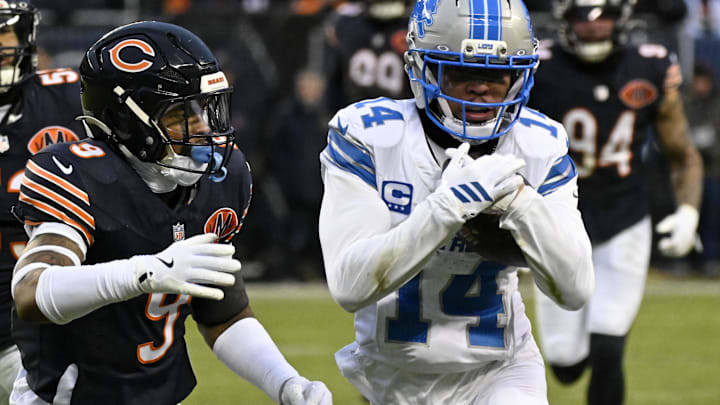 Jan 4, 2026; Chicago, Illinois, USA; Detroit Lions wide receiver Amon-Ra St. Brown (14) runs with the ball against Chicago Bears safety Jaquan Brisker (9) during the first half at Soldier Field. Mandatory Credit: Matt Marton-Imagn Images
