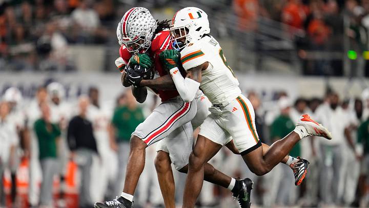 Ohio State Buckeyes wide receiver Jeremiah Smith (4) makes a catch defended by Miami Hurricanes cornerback Xavier Lucas (6) during the Cotton Bowl at AT&T Stadium in Arlington, Texas for the College Football Playoff quarterfinal game on Dec. 31, 2025. Ohio State Buckeyes wide receiver Jeremiah Smith (4) makes a catch defended by Miami Hurricanes cornerback Xavier Lucas (6) during the Cotton Bowl at AT&T Stadium in Arlington, Texas for the College Football Playoff quarterfinal game on Dec. 31, 2025.