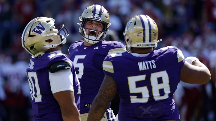 Washington Huskies wide receiver Christian Moss (5) celebrates an interception with defensive lineman Elinneus Davis (90) and  defensive lineman DeSean Watts (58).
