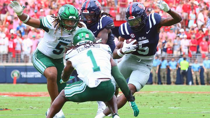 Sep 20, 2025; Oxford, Mississippi, USA; Mississippi Rebels running back Kewan Lacy (5) runs the ball as Tulane Green Wave defensive end Harvey Dyson (5) and Tulane Green Wave defensive back Jack Tchienchou (1) attempt to make the tackle during the first quarter at Vaught-Hemingway Stadium. Mandatory Credit: Petre Thomas-Imagn Images Sep 20, 2025; Oxford, Mississippi, USA; Mississippi Rebels running back Kewan Lacy (5) runs the ball as Tulane Green Wave defensive end Harvey Dyson (5) and Tulane Green Wave defensive back Jack Tchienchou (1) attempt to make the tackle during the first quarter at Vaught-Hemingway Stadium. Mandatory Credit: Petre Thomas-Imagn Images