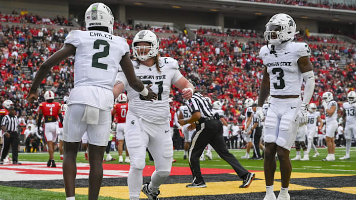 Sep 7, 2024; College Park, Maryland, USA; Michigan State Spartans quarterback Aidan Chiles (2) celebrates with teammates in the enzyme after throwing a first quarter touchdown against the Maryland Terrapins  at SECU Stadium. Mandatory Credit: Tommy Gilligan-Imagn Images