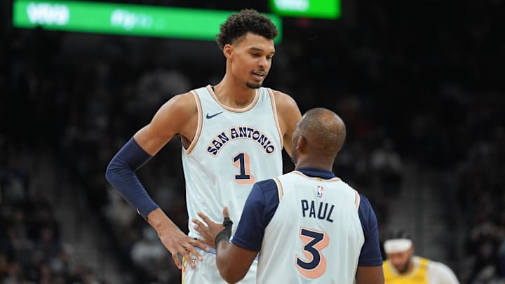 Nov 27, 2024; San Antonio, Texas, USA;  San Antonio Spurs center Victor Wembanyama (1) talks with guard Chris Paul (3) in the second half against the Los Angeles Lakers at Frost Bank Center. Mandatory Credit: Daniel Dunn-Imagn Images