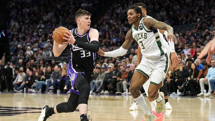 Mar 22, 2025; Sacramento, California, USA; Sacramento Kings forward Jake LaRavia (33) drives against Milwaukee Bucks guard Kevin Porter Jr. (3) during the fourth quarter at Golden 1 Center. Mandatory Credit: Darren Yamashita-Imagn Images