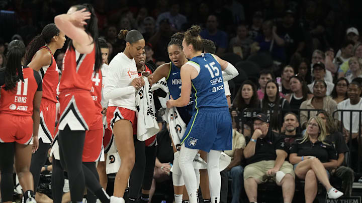 Aug 2, 2025; Las Vegas, Nevada, USA; Players from the Las Vegas Aces and Minnesota Lynx surround Lynx forward Napheesa Collier (24) after she does down with an injury in the third quarter of their game at Michelob Ultra Arena. Mandatory Credit: Candice Ward-Imagn Images