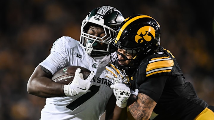 Nov 22, 2025; Iowa City, Iowa, USA; Michigan State Spartans running back Brandon Tullis (7) runs for yards after the catch as Iowa Hawkeyes defensive back Koen Entringer (4) makes the tackle during the third quarter at Kinnick Stadium. Mandatory Credit: Jeffrey Becker-Imagn Images Nov 22, 2025; Iowa City, Iowa, USA; Michigan State Spartans running back Brandon Tullis (7) runs for yards after the catch as Iowa Hawkeyes defensive back Koen Entringer (4) makes the tackle during the third quarter at Kinnick Stadium. Mandatory Credit: Jeffrey Becker-Imagn Images
