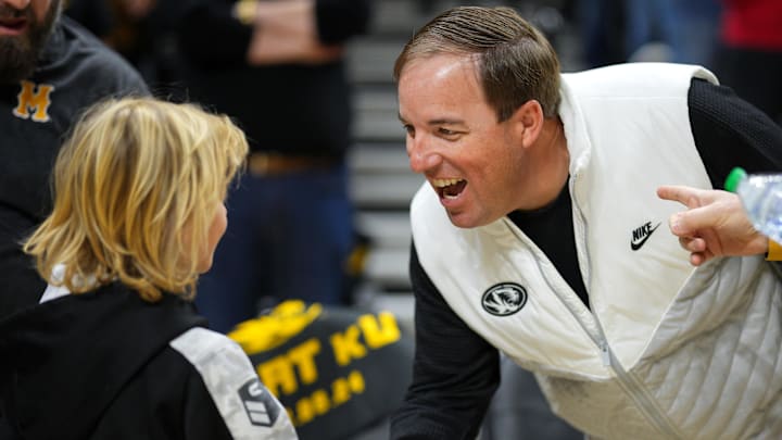 Dec 8, 2024; Columbia, Missouri, USA; Missouri Tigers football head coach Eliah Drinkwitz greets a young fan prior to a game against the Kansas Jayhawks at Mizzou Arena. Mandatory Credit: Jay Biggerstaff-Imagn Images