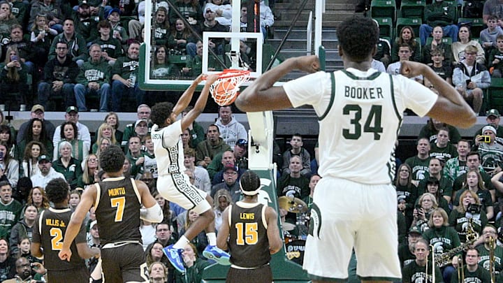 Dec 30, 2024; East Lansing, Michigan, USA;  Michigan State Spartans guard Jase Richardson (11) dunks the ball as teammate Xavier Booker (34) reacts during the first half against the Western Michigan Broncos at Jack Breslin Student Events Center. Mandatory Credit: Dale Young-Imagn Images
