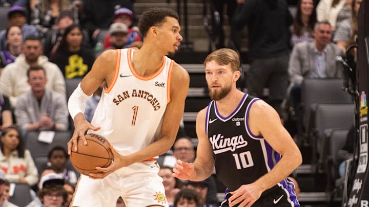 Feb 22, 2024; Sacramento, California, USA; San Antonio Spurs center Victor Wembanyama (1) controls the ball against Sacramento Kings forward Domantas Sabonis (10) during the first quarter at Golden 1 Center.