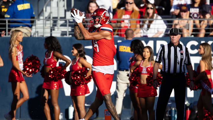 Nov 30, 2024; Tucson, Arizona, USA; Arizona Wildcats wide receiver Tetairoa McMillan (4) catches a touchdown against the Arizona State Sun Devils in the second half during the Territorial Cup at Arizona Stadium. Mandatory Credit: Mark J. Rebilas-Imagn Images