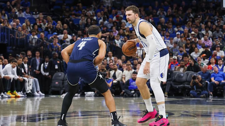 Dallas Mavericks guard Luka Doncic (77) handles the ball against Orlando Magic guard Jalen Suggs (4) during the first quarter at Amway Center.