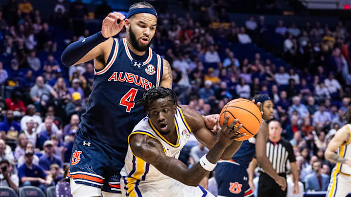 Jan 29, 2025; Baton Rouge, Louisiana, USA;  LSU Tigers forward Corey Chest (11) dribbles against Auburn Tigers forward Johni Broome (4) during the first half at Pete Maravich Assembly Center. Mandatory Credit: Stephen Lew-Imagn Images
