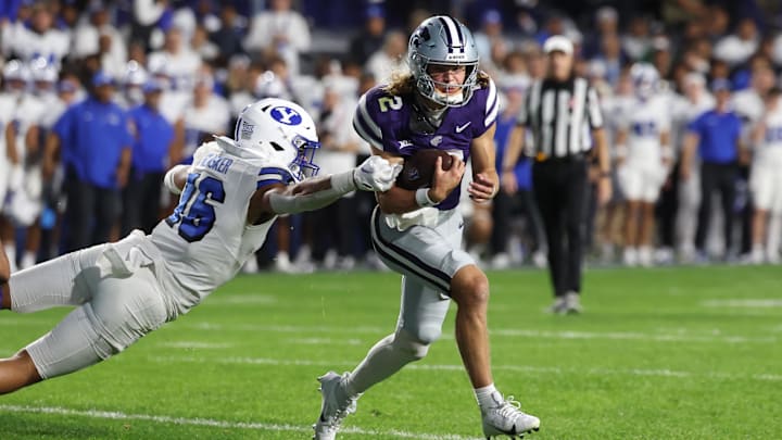 Sep 21, 2024; Provo, Utah, USA; Kansas State Wildcats quarterback Avery Johnson (2) breaks a tackle by Brigham Young Cougars linebacker Isaiah Glasker (16) during the third quarter at LaVell Edwards Stadium. Mandatory Credit: Rob Gray-Imagn Images