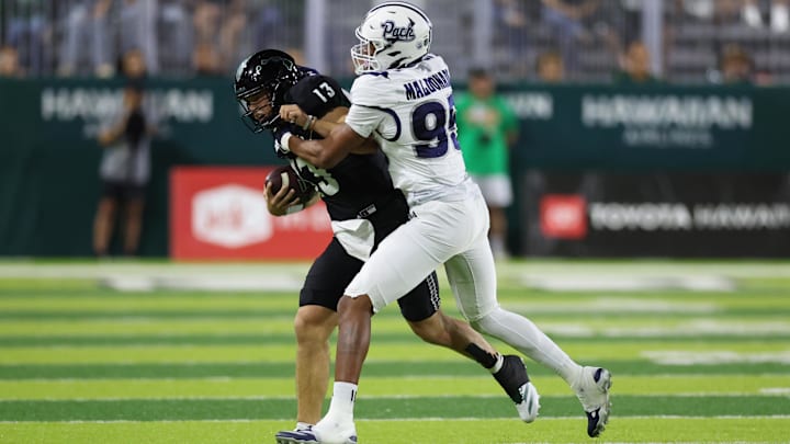Oct 26, 2024; Honolulu, Hawaii, USA;  Nevada Wolf Pack linebacker Jonathan Maldonado (95) shoves Hawaii Rainbow Warriors quarterback Brayden Schager (13) out of bounds during the first quarter of an NCAA college football game at the Clarence T.C. Ching Athletics Complex. Mandatory Credit: Marco Garcia-Imagn Images