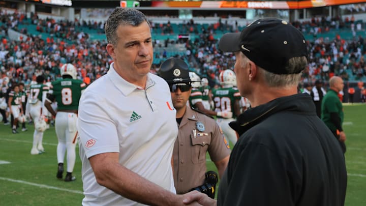 Nov 23, 2024; Miami Gardens, Florida, USA; Miami Hurricanes head coach Mario Cristobal shakes hands with Wake Forest Demon Deacons head coach Dave Clawson after the game at Hard Rock Stadium. Mandatory Credit: Sam Navarro-Imagn Imagesa Nov 23, 2024; Miami Gardens, Florida, USA; Miami Hurricanes head coach Mario Cristobal shakes hands with Wake Forest Demon Deacons head coach Dave Clawson after the game at Hard Rock Stadium. Mandatory Credit: Sam Navarro-Imagn Imagesa