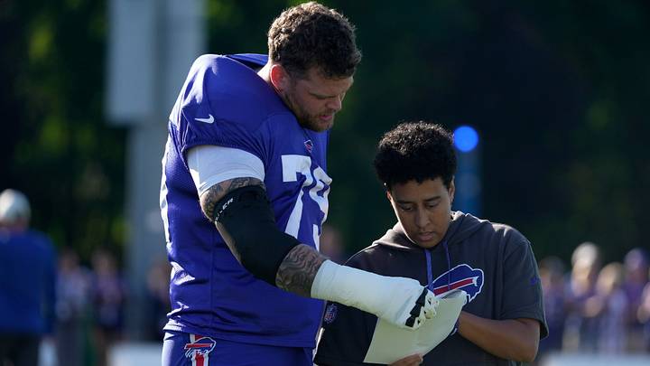 Buffalo Bills veteran right tackle Spencer Brown (left) looks over a play-call sheet with Milli Wilson, who's an offensive assistant coach, before practice at Bills training camp at St. John Fisher University in Pittsford, New York, on Aug. 4, 2026.