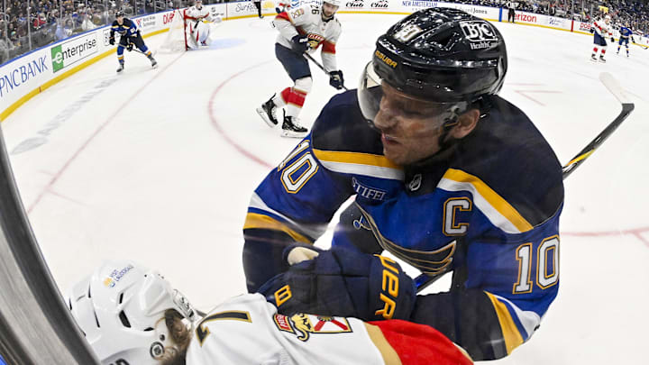 Feb 6, 2025; St. Louis, Missouri, USA;  St. Louis Blues center Brayden Schenn (10) checks Florida Panthers center Jesper Boqvist (70) during the second period at Enterprise Center. Mandatory Credit: Jeff Curry-Imagn Images