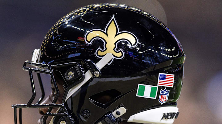 Sep 7, 2025; New Orleans, Louisiana, USA;  Detailed view of the helmet worn by New Orleans Saints safety Ugo Amadi (0) with and American Flag and the flag of Nigeria during warmups against the Arizona Cardinals at Caesars Superdome. 