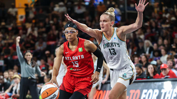Aug 23, 2025; College Park, Georgia, USA; Atlanta Dream guard Allisha Gray (15) drives the ball towards the basket against New York Liberty forward Leonie Fiebich (13) during the first quarter at Gateway Center Arena at College Park. Mandatory Credit: Jordan Godfree-Imagn Images