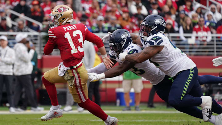 Nov 17, 2024; Santa Clara, California, USA; San Francisco 49ers quarterback Brock Purdy (13) scrambles away from Seattle Seahawks linebacker Boye Mafe (53) and Seattle Seahawks defensive tackle Byron Murphy II (91) in the third quarter at Levi's Stadium. Mandatory Credit: David Gonzales-Imagn Images Nov 17, 2024; Santa Clara, California, USA; San Francisco 49ers quarterback Brock Purdy (13) scrambles away from Seattle Seahawks linebacker Boye Mafe (53) and Seattle Seahawks defensive tackle Byron Murphy II (91) in the third quarter at Levi's Stadium. Mandatory Credit: David Gonzales-Imagn Images