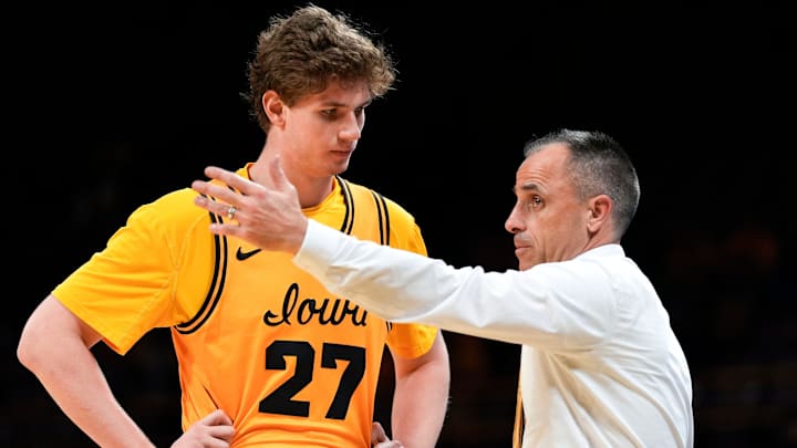 Iowa Hawkeyes head coach Ben McCollum talks to Iowa center Trevin Jirak (27) 