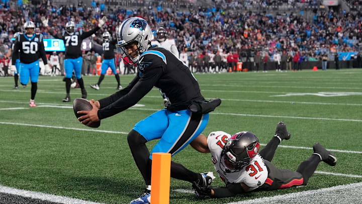 Dec 1, 2024; Charlotte, North Carolina, USA;  Carolina Panthers quarterback Bryce Young (9) scores a touchdown as Tampa Bay Buccaneers safety Antoine Winfield Jr. (31) defends in the second quarter at Bank of America Stadium. Mandatory Credit: Bob Donnan-Imagn Images