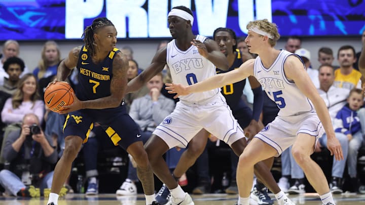 Mar 1, 2025; Provo, Utah, USA; West Virginia Mountaineers guard Javon Small (7) looks for a play against Brigham Young Cougars forward Mawot Mag (0) and forward Richie Saunders (15) during the first half at Marriott Center. Mandatory Credit: Rob Gray-Imagn Images Mar 1, 2025; Provo, Utah, USA; West Virginia Mountaineers guard Javon Small (7) looks for a play against Brigham Young Cougars forward Mawot Mag (0) and forward Richie Saunders (15) during the first half at Marriott Center. Mandatory Credit: Rob Gray-Imagn Images