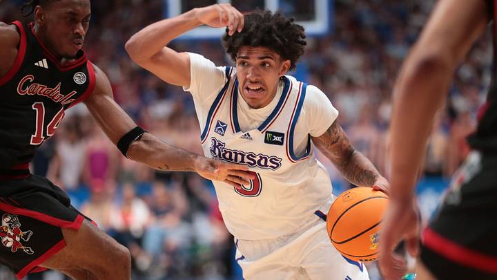 Kansas Jayhawks guard Taylen Kinney (0) drives the bal against Louisville Cardinals guard Adrian Wooley (14) during the exhibition game inside Allen Fieldhouse in Lawrence, Kansas on Oct. 21, 2026.