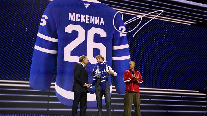 Jun 26, 2026; Buffalo, New York, USA; Gavin McKenna puts on a sweater beside NHL commissioner Gary Bettman and singer Justin Bieber after being selected with the first pick in the first round of the 2026 NHL Draft by the Toronto Maple Leafs at KeyBank Center. Mandatory Credit: Timothy T. Ludwig-Imagn Images