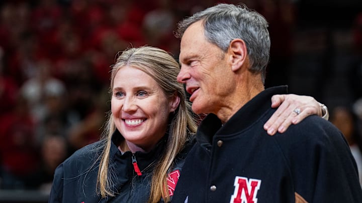 Dani Busboom Kelly and John Cook embrace while being recognized during a first-half break in the Nebraska-Illinois men's basketball game.