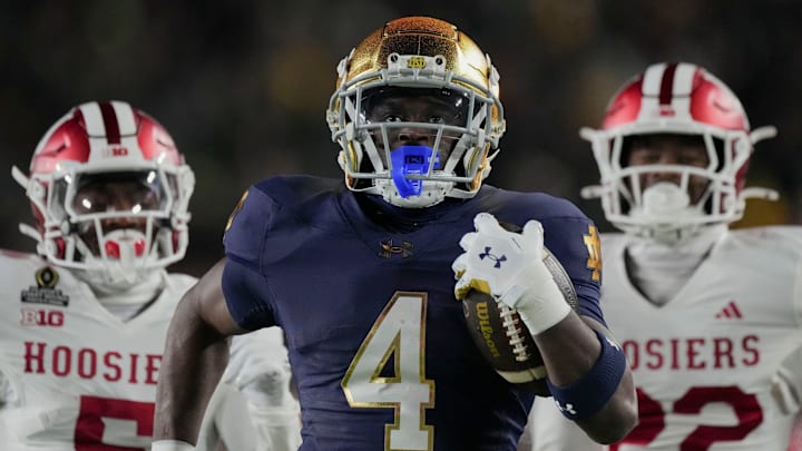 Notre Dame Fighting Irish running back Jeremiyah Love (4) scores a touchdown while being chased by Indiana Hoosiers defensive back D'Angelo Ponds (5) and Indiana Hoosiers defensive back Jamari Sharpe (22) during the first half of a game between the Indiana Hoosiers and the Notre Dame Fighting Irish in first round of the College Football Playoff on Friday, Dec. 20, 2024, in South Bend.