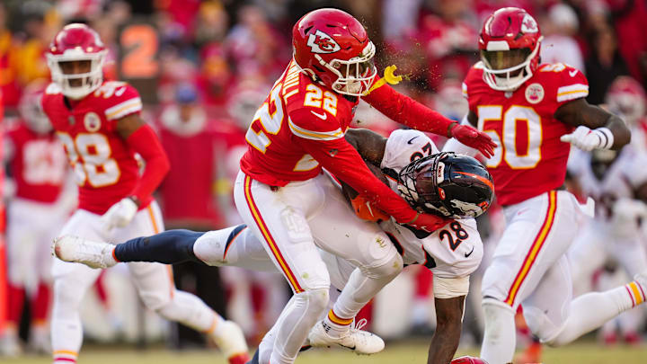 Jan 1, 2023; Kansas City, Missouri, USA; Denver Broncos running back Latavius Murray (28) is tackled by Kansas City Chiefs safety Juan Thornhill (22) and safety Justin Reid (20) during the second half at GEHA Field at Arrowhead Stadium. Mandatory Credit: Jay Biggerstaff-Imagn Images