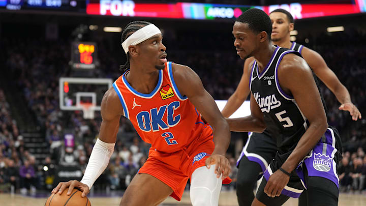 Dec 14, 2023; Sacramento, California, USA; Oklahoma City Thunder guard Shai Gilgeous-Alexander (2) dribbles against Sacramento Kings guard De'Aaron Fox (5) during the fourth quarter at Golden 1 Center. Mandatory Credit: Darren Yamashita-Imagn Images