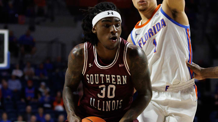 Nov 22, 2024; Gainesville, Florida, USA; Southern Illinois Salukis guard Kennard Davis Jr. (30) drives to the basket past Florida Gators guard Walter Clayton Jr. (1) and Florida Gators center Rueben Chinyelu (9) during the first half at Exactech Arena at the Stephen C. O'Connell Center. Mandatory Credit: Matt Pendleton-Imagn Images