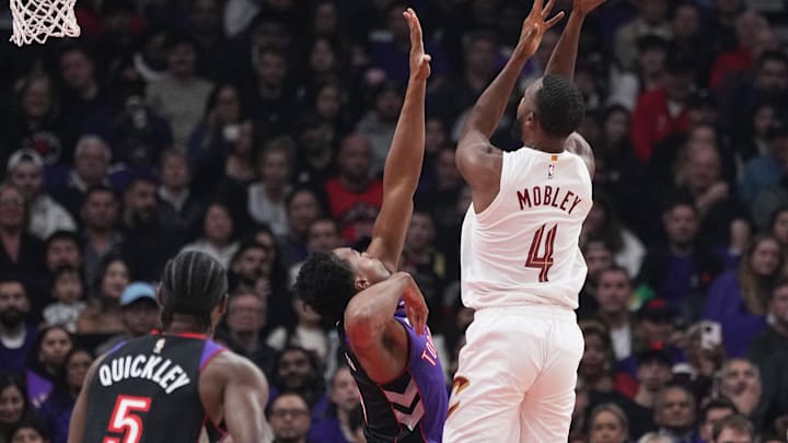 Oct 23, 2024; Toronto, Ontario, CAN; Cleveland Cavaliers forward Evan Mobley (4) attempts a shot as Toronto Raptors forward Scottie Barnes (4) tries to defend during the first quarter at Scotiabank Arena. Mandatory Credit: Nick Turchiaro-Imagn Images