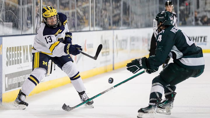 Michigan center TJ Hughes makes a pass against Michigan State defenseman Nash Nienhuis during the third period at Yost Ice Arena in Ann Arbor on Friday, Feb. 9, 2024.