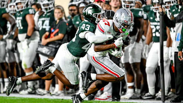 Michigan State's Malik Spencer, left, tackles Ohio State's Carnell Tate during the first quarter on Saturday, Sept. 28, 2024, at Spartan Stadium in East Lansing.