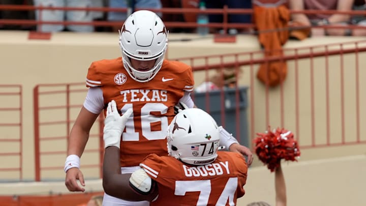 Texas Longhorns offensive lineman Trevor Goosby lifts quarterback Arch Manning