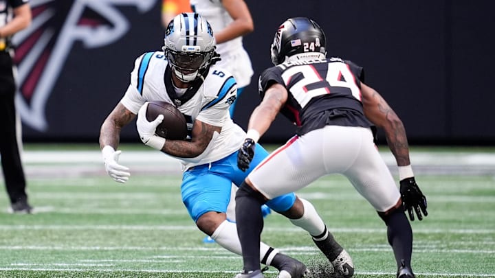 Nov 16, 2025; Atlanta, Georgia, USA; Carolina Panthers running back Rico Dowdle (5) runs with the ball while being defended by Atlanta Falcons cornerback A.J. Terrell Jr. (24) in the first quarter at Mercedes-Benz Stadium. Mandatory Credit: Dale Zanine-Imagn Images