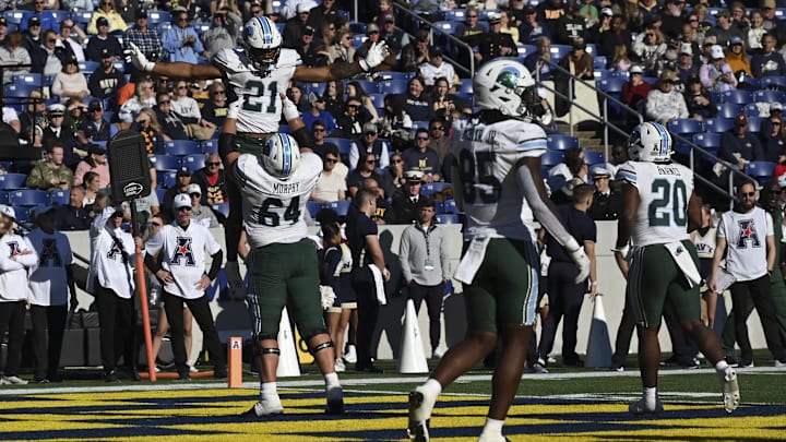 Nov 16, 2024; Annapolis, Maryland, USA; Tulane Green Wave running back Makhi Hughes (21) celebrates with center Brent Self (65) after scoring a touchdown during the second half  against the Navy Midshipmen at Navy-Marine Corps Memorial Stadium.