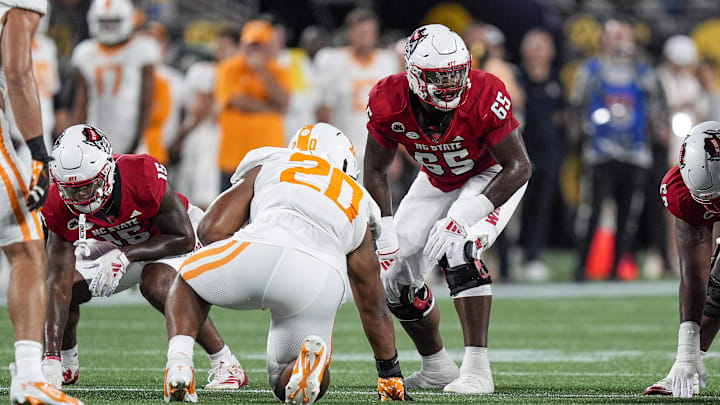 Sep 7, 2024; Charlotte, North Carolina, USA; North Carolina State Wolfpack offensive tackle Jacarrius Peak (65) lines up against Tennessee Volunteers defensive lineman Bryson Eason (20) during the first quarter at the Dukes Mayo Classic at Bank of America Stadium. Mandatory Credit: Jim Dedmon-Imagn Images