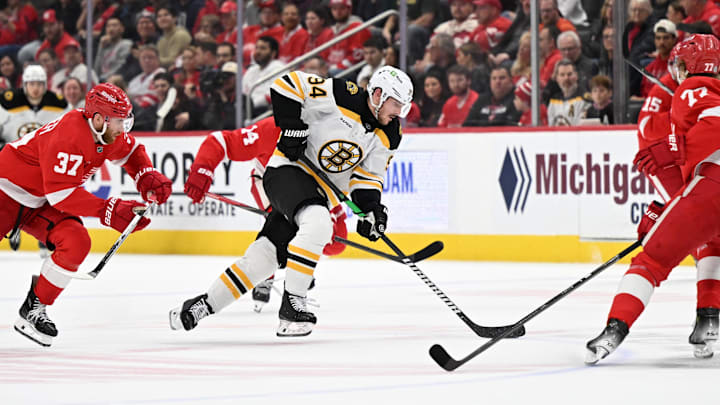 Mar 29, 2025; Detroit, Michigan, USA;  Boston Bruins center Jakub Lauko (94) skates past Detroit Red Wings left wing J.T. Compher (37)  in the first period at Little Caesars Arena. Mandatory Credit: Lon Horwedel-Imagn Images