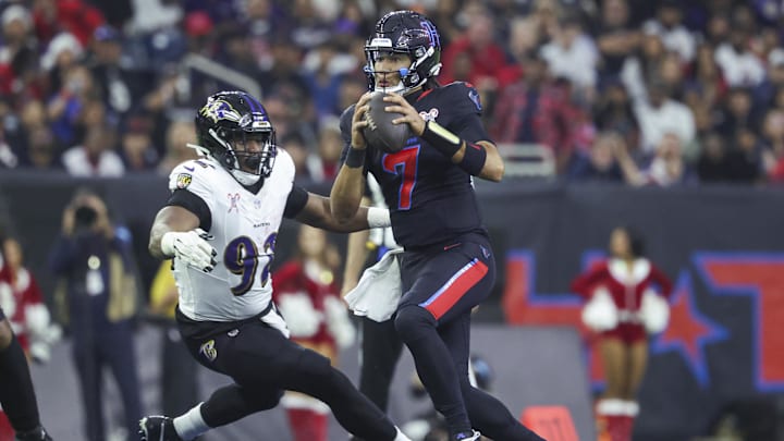 Dec 15, 2024; Houston, Texas, USA; Houston Texans quarterback C.J. Stroud (7) looks for an open receiver as Baltimore Ravens defensive tackle Nnamdi Madubuike (92) attempts to make a tackle during the second quarter at NRG Stadium. Mandatory Credit: Troy Taormina-Imagn Images