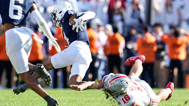 Ohio State Buckeyes QB Will Howard tackles Penn State Nittany Lions CB A.J. Harris during the second half of the NCAA football game at Beaver Stadium.